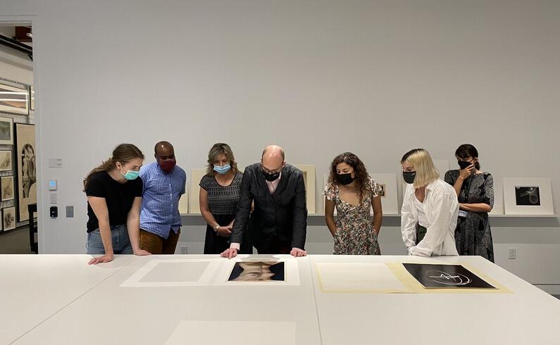 group of people look at artwork on a table